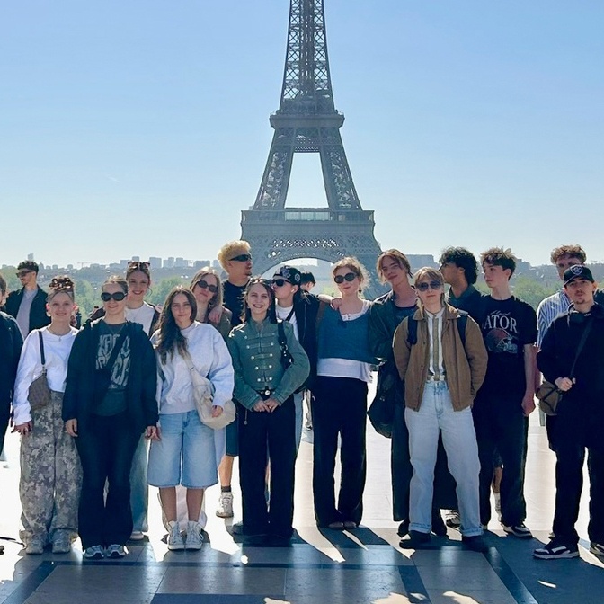 Die Klasse des Gestalterischen Vorkurses vor dem Eiffelturm während einer Studienreise nach Paris.